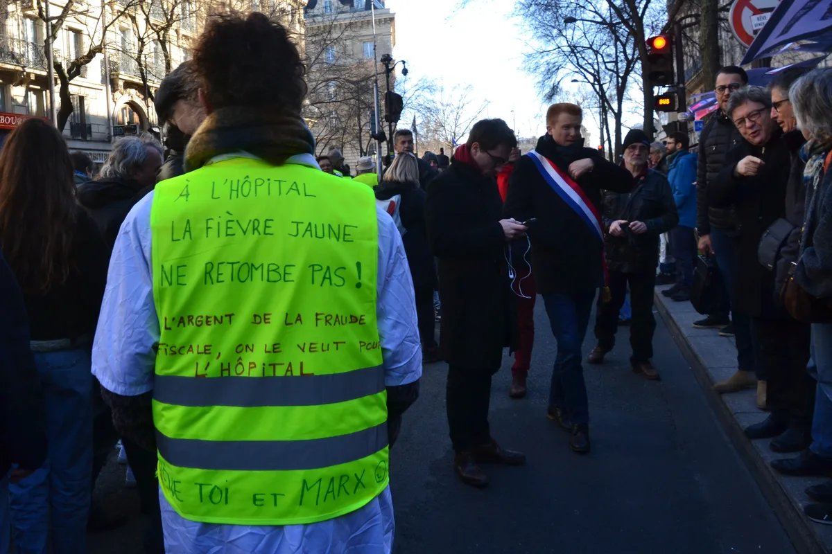 A protester wearing a gilet jaune yellow vest at a Paris demonstration